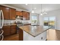 Gourmet kitchen features stainless steel appliances and granite counters and access to a deck at 12201 Village Cir, Brighton, CO 80603