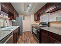 Galley kitchen featuring dark wood cabinets, granite countertops, and stainless steel appliances at 13393 E Asbury Dr # 103, Aurora, CO 80014