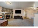 Inviting living room with a stone fireplace, large screen TV, and cozy ambiance at 13393 E Asbury Dr # 103, Aurora, CO 80014