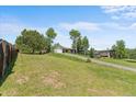 Expansive grassy front yard with mature trees leading to a cozy home with a driveway at 8427 S Custer Ln, Evergreen, CO 80439