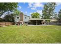 Spacious backyard features a large lawn, covered patio, and play set, great for outdoor enjoyment at 8935 W Swarthmore Dr, Littleton, CO 80123