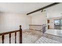 View of the living room with exposed ceiling beams, staircase, and open layout leading to the kitchen at 831 Sable Blvd, Aurora, CO 80011