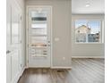 Bright entryway featuring a stylish front door with glass panels and wood-look flooring at 7360 Watercress Dr, Littleton, CO 80125