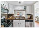 Functional kitchen features stainless steel appliances, ample counter space, and white cabinetry with a view to the living area at 6650 E Arizona Ave # 154, Denver, CO 80224