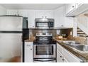 Efficient kitchen with stainless steel appliances, white cabinetry, and practical countertops at 6650 E Arizona Ave # 154, Denver, CO 80224