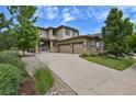 Beautiful two-story home boasts a three-car garage, lush lawn and attractive stone and wood finishes at 24269 E Arapahoe Pl, Aurora, CO 80016