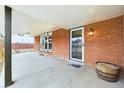 Inviting front porch featuring a brick exterior, bay window, and stylish front door at 6410 S Kendall St, Littleton, CO 80123