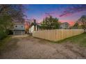 Rear exterior view showcasing the house, detached garage, and driveway, enclosed by a wooden fence for privacy at 5326 Lowell Blvd, Denver, CO 80221