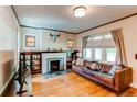 Comfortable living room featuring a fireplace, hardwood flooring, and large windows at 1844 S Lincoln St, Denver, CO 80210