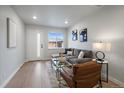 Cozy living room featuring a sectional couch, stylish decor, and plenty of natural light from a window at 3738 N Eliot St # 2, Denver, CO 80211