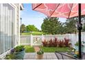 Outdoor patio area with a view of the manicured lawn and pink umbrella at 7 Shetland Ct, Highlands Ranch, CO 80130