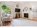 Bright living room with a fireplace, accent chair, and lots of natural light from the big window at 7 Shetland Ct, Highlands Ranch, CO 80130
