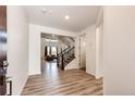 Bright foyer with wood-look flooring, staircase, and open access to the living areas of the home at 985 S Elk Way, Aurora, CO 80018