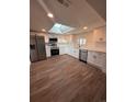 Bright kitchen with stainless steel appliances, white cabinets, and a skylight for natural light at 1337 Ames St, Lakewood, CO 80214