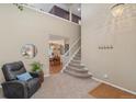 Inviting living room featuring staircase, high ceilings, and cozy seating area at 9230 W Indore Dr, Littleton, CO 80128
