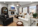 Bright and airy living room featuring a beautiful stone fireplace and large windows at 9035 S Shawnee Ct, Aurora, CO 80016