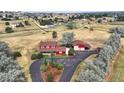 Aerial view of a red two-story home with a large driveway on a lush lot with outbuildings at 20155 E Davies Ave, Centennial, CO 80016