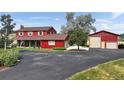 View of two-story red home featuring mature landscaping and a spacious driveway at 20155 E Davies Ave, Centennial, CO 80016