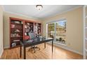 Bright office featuring hardwood floors, large window and a built-in bookshelf at 7197 S Newland St, Littleton, CO 80128