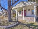 Inviting home exterior featuring a covered porch with supporting columns and a decorative front yard fence at 2015 Elmira St, Aurora, CO 80010