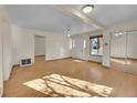 Bright living room with hardwood floors, ceiling fan, and a mirrored closet door, bathed in natural light at 2015 Elmira St, Aurora, CO 80010