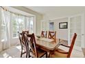Sunlit dining room showcasing a large wooden table, chairs, and bay windows at 7081 S Oak Hill Cir, Aurora, CO 80016