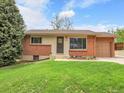 Beautiful front exterior of a charming home featuring well-kept lawn, beautiful brick accents and a lovely front door at 2797 S Newton Way, Denver, CO 80236
