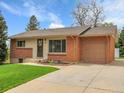 Charming exterior of a brick and siding home with a well-manicured lawn and a wide driveway at 2797 S Newton Way, Denver, CO 80236