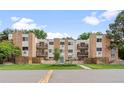 Exterior view of a multi-unit building with balconies, brick accents, and well-maintained lawns at 2835 S Monaco Pkwy # 1-103, Denver, CO 80222
