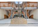 Apartment building exterior featuring multiple levels with open staircases and landscaped rock garden at 2835 S Monaco Pkwy # 1-103, Denver, CO 80222