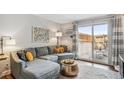 Comfortable living room area featuring a couch, patio access, and stylish accents at 2835 S Monaco Pkwy # 1-103, Denver, CO 80222