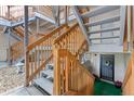 Apartment staircase with wooden railings leading to upper levels, with decorative front door and potted plants at 2835 S Monaco Pkwy # 1-103, Denver, CO 80222