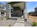 Inviting front porch featuring stylish stone accents and covered entryway at 20871 E 60Th Ave, Aurora, CO 80019