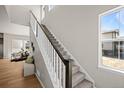 Bright staircase with carpeted steps and white railings leading to upper level at 20871 E 60Th Ave, Aurora, CO 80019