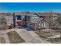 Charming two-story home with a brick and siding exterior, a red front door, and a spacious driveway at 4812 S Fultondale Way, Aurora, CO 80016