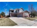 Well-maintained two-story house featuring brick accents, grey siding, and a concrete driveway at 4812 S Fultondale Way, Aurora, CO 80016