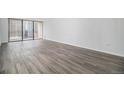 Spacious living room featuring new gray wood flooring and large balcony doors at 1020 15Th St # 15G, Denver, CO 80202