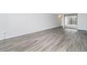 Open living area with gray wood flooring, mirrored closet doors, and white walls at 1020 15Th St # 15G, Denver, CO 80202
