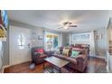 Bright living room featuring hardwood floors, natural light, and comfortable seating, great for relaxation and entertaining at 7081 Warren Dr, Denver, CO 80221