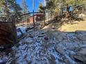 View of the wooded, fenced backyard and surrounding trees at 11130 Burland Dr, Golden, CO 80403