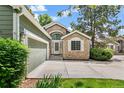 Charming home featuring stone accents, a well-manicured lawn, and an attached two-car garage at 7400 W Grant Ranch Blvd # 52, Littleton, CO 80123
