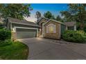 Charming home featuring stone accents, a well-manicured lawn, and an attached two-car garage at dusk at 7400 W Grant Ranch Blvd # 52, Littleton, CO 80123