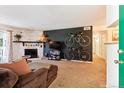 Cozy living room featuring a stone fireplace, dark accent wall, and bicycle wall decor at 8555 Fairmount Dr # B202, Denver, CO 80247