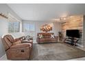 Inviting living room with plush seating, natural light, and modern entertainment center with a wood accent wall at 8798 Chase Dr # 4, Arvada, CO 80003