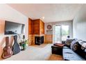 Comfortable living room featuring a fireplace, balcony access, and ample natural light at 2280 S Oswego Way # 303, Aurora, CO 80014