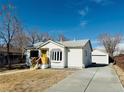 View of the house, freshly poured driveway and detached garage at 6631 E 77Th Pl, Commerce City, CO 80022