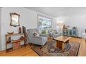 Cozy living area features hardwood floors, comfortable seating, and natural light from a nearby window at 2117 S Balsam Ct, Lakewood, CO 80227