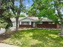 Charming brick ranch-style home with a well-maintained lawn and mature trees providing shade at 3784 Swadley St, Wheat Ridge, CO 80033