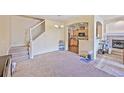 Spacious living area features carpet, a fireplace, stairs, and an open view to the kitchen at 12711 Colorado Blvd # 914, Thornton, CO 80241