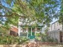 Charming two-story brick home with green accents and lush landscaped front yard at 1612 N High St, Denver, CO 80218